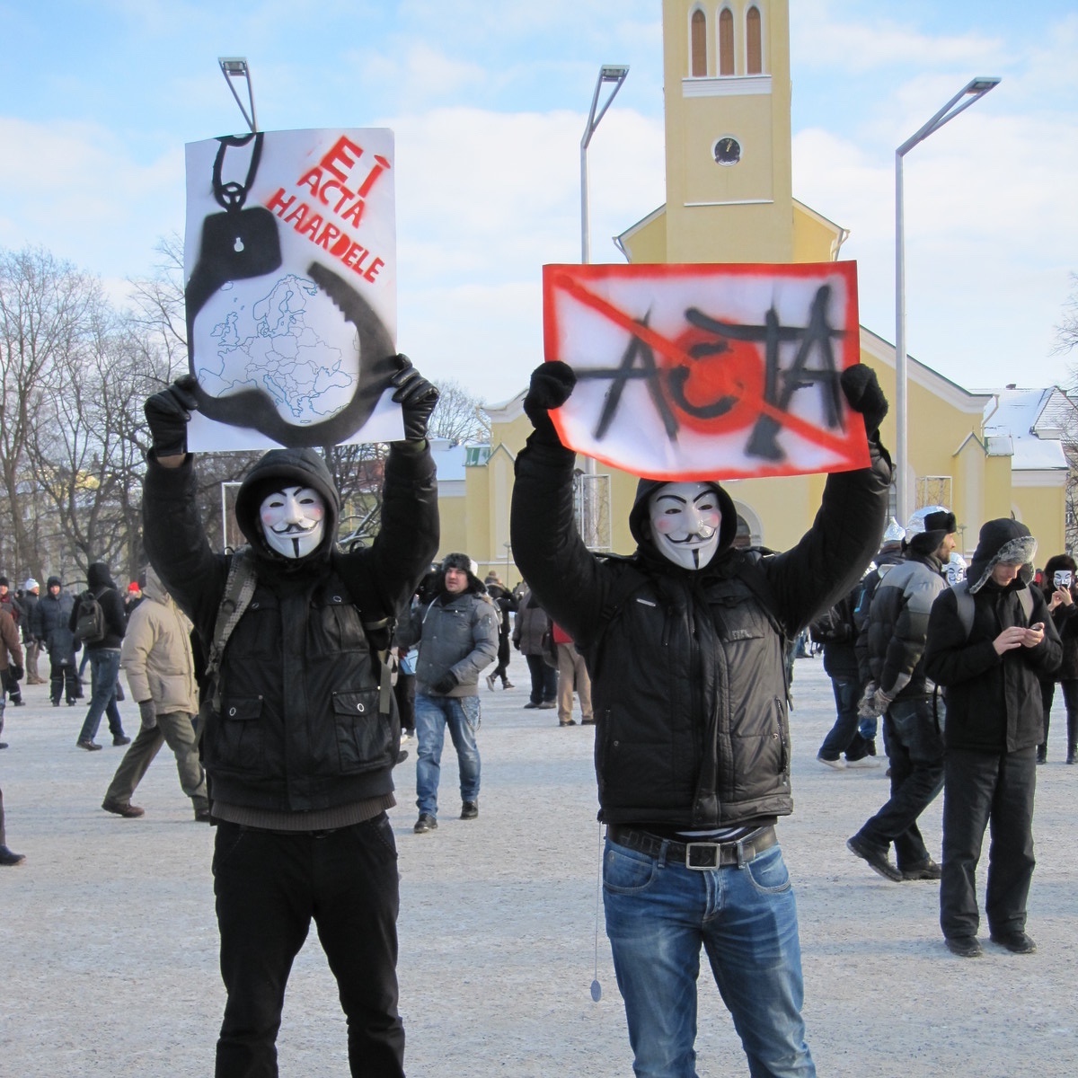 Foto: Zwei Anti-ACTA-Demonstranten mit Guy Fawkes-Masken und hochgehaltenen Transparenten