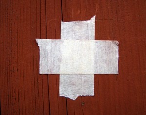 Foto: Schweizer Fahne aus kreuzweise übereinandergelegten weissen Stoffbahnen auf rotem Holz