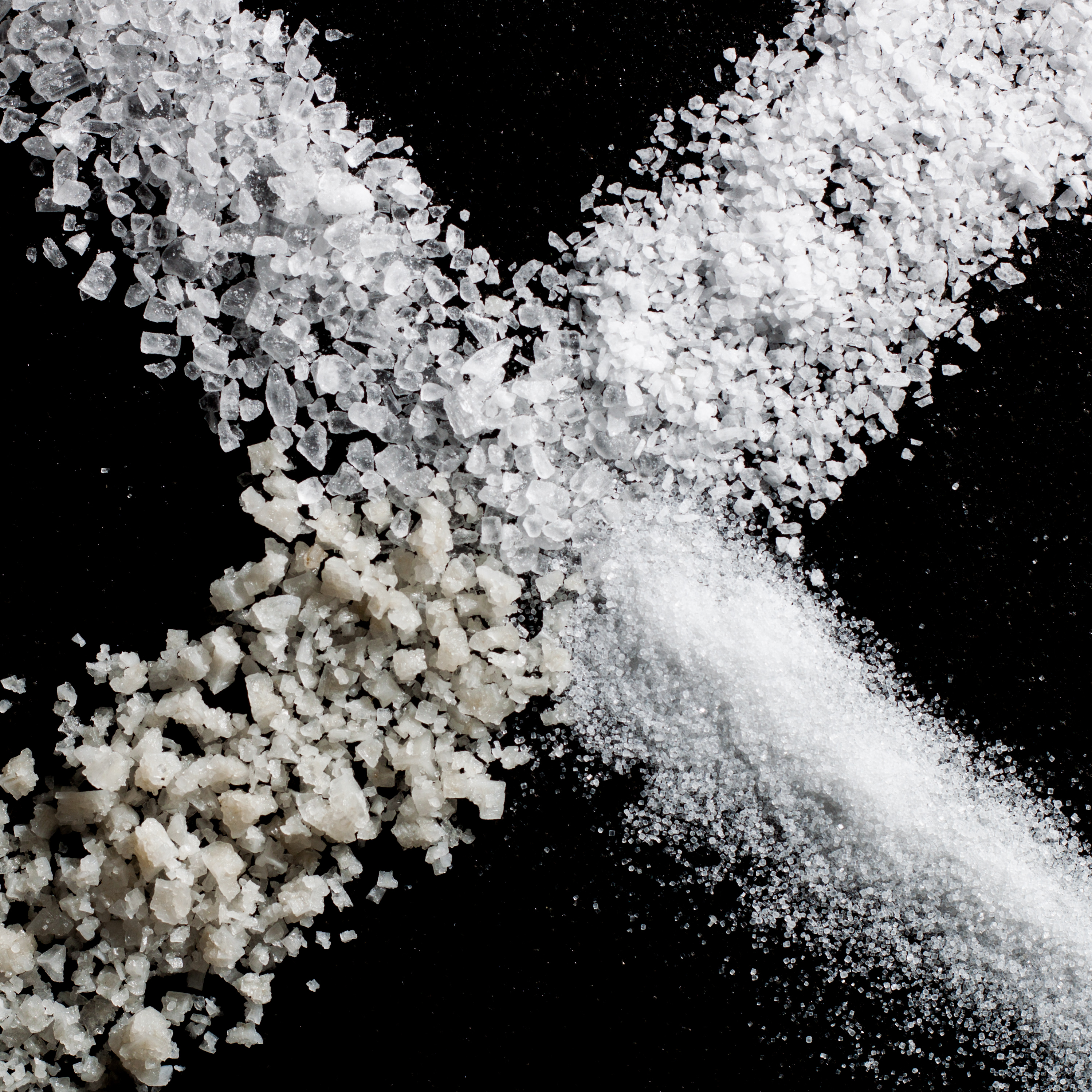 Foto: Vier Arten von Salz als Kreuz angeordnet (mit je einer Salzsorte als Kreuzarm)
