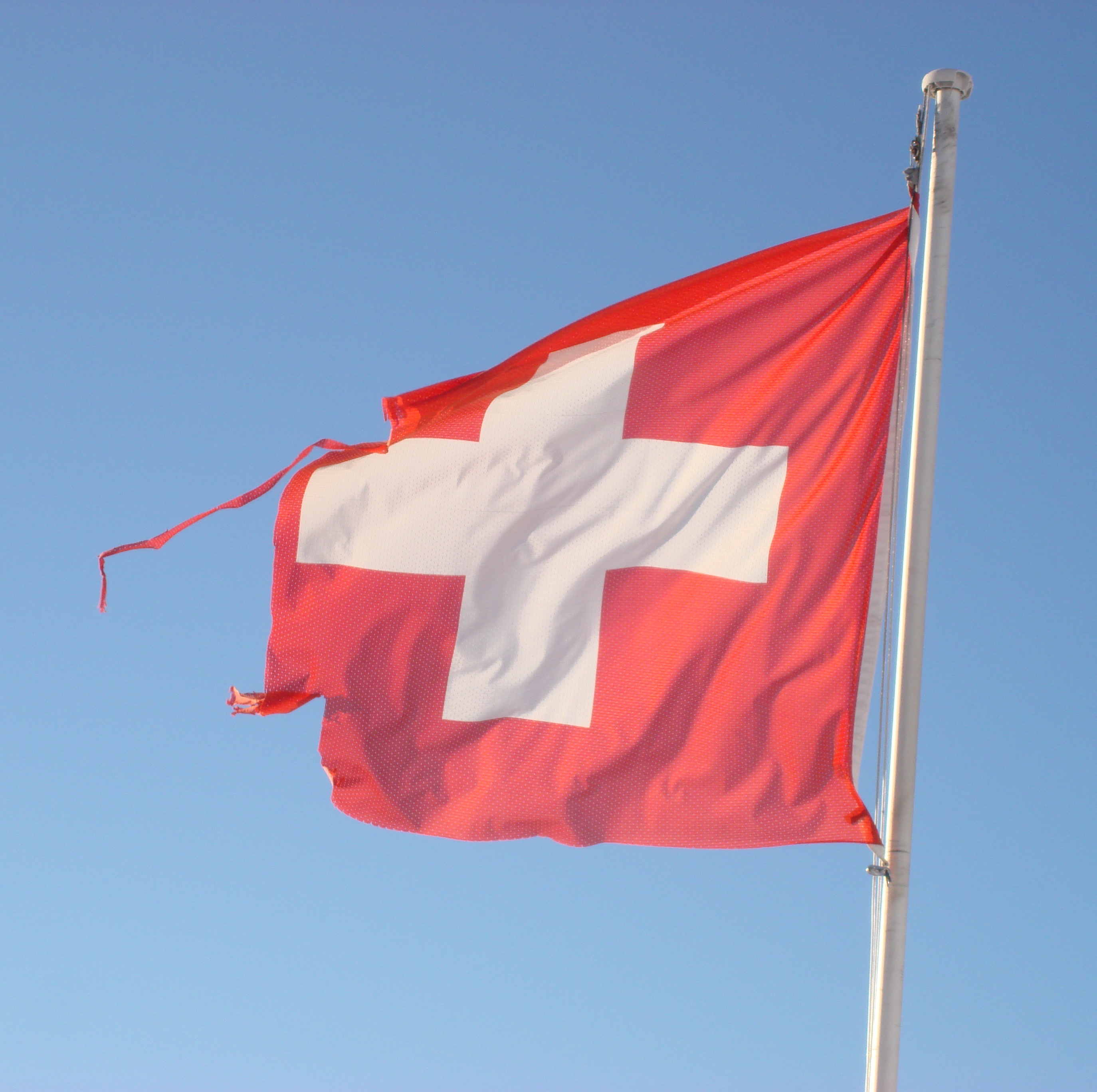 Foto: Leicht zerfledderte Schweizer Fahne im Wind