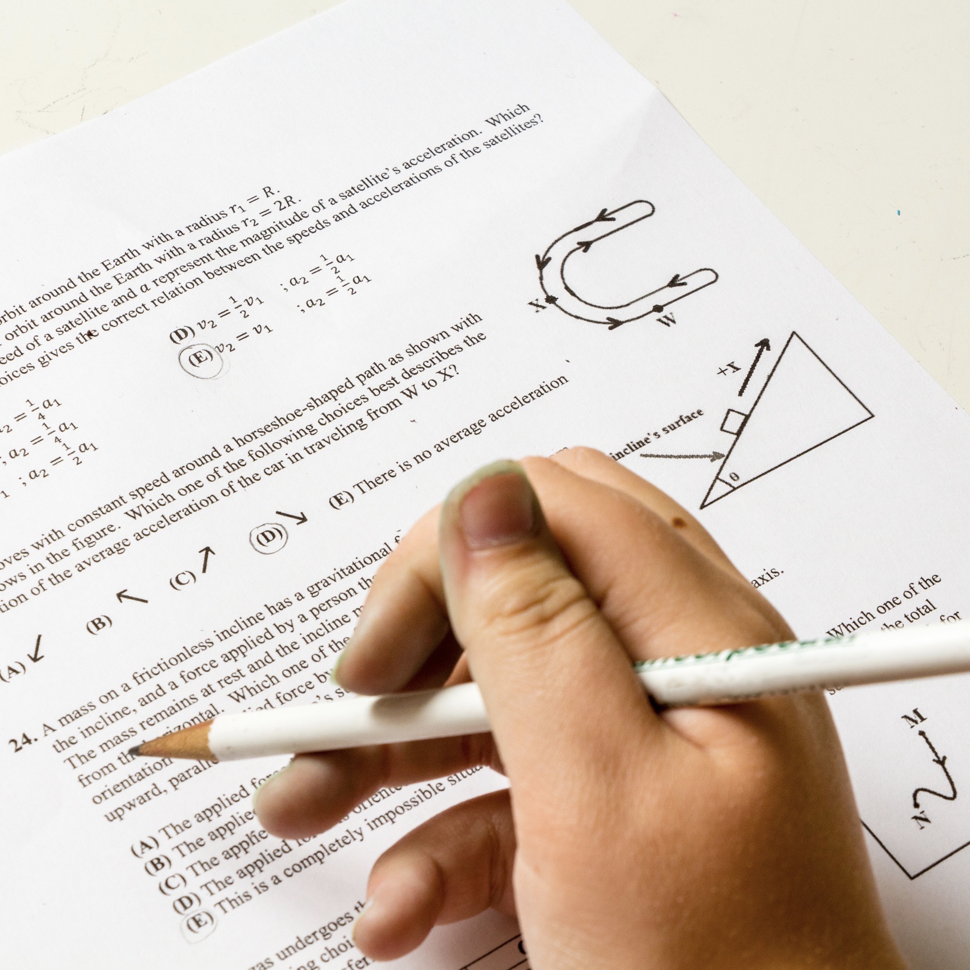 Foto: Hand mit Bleistift, die Prüfungsaufgaben löst (Symbolbild)