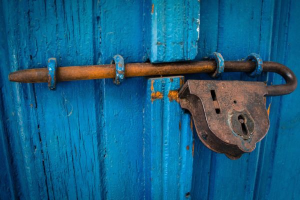 Foto: Rostiges Vorhängeschloss an blauer Holztüre