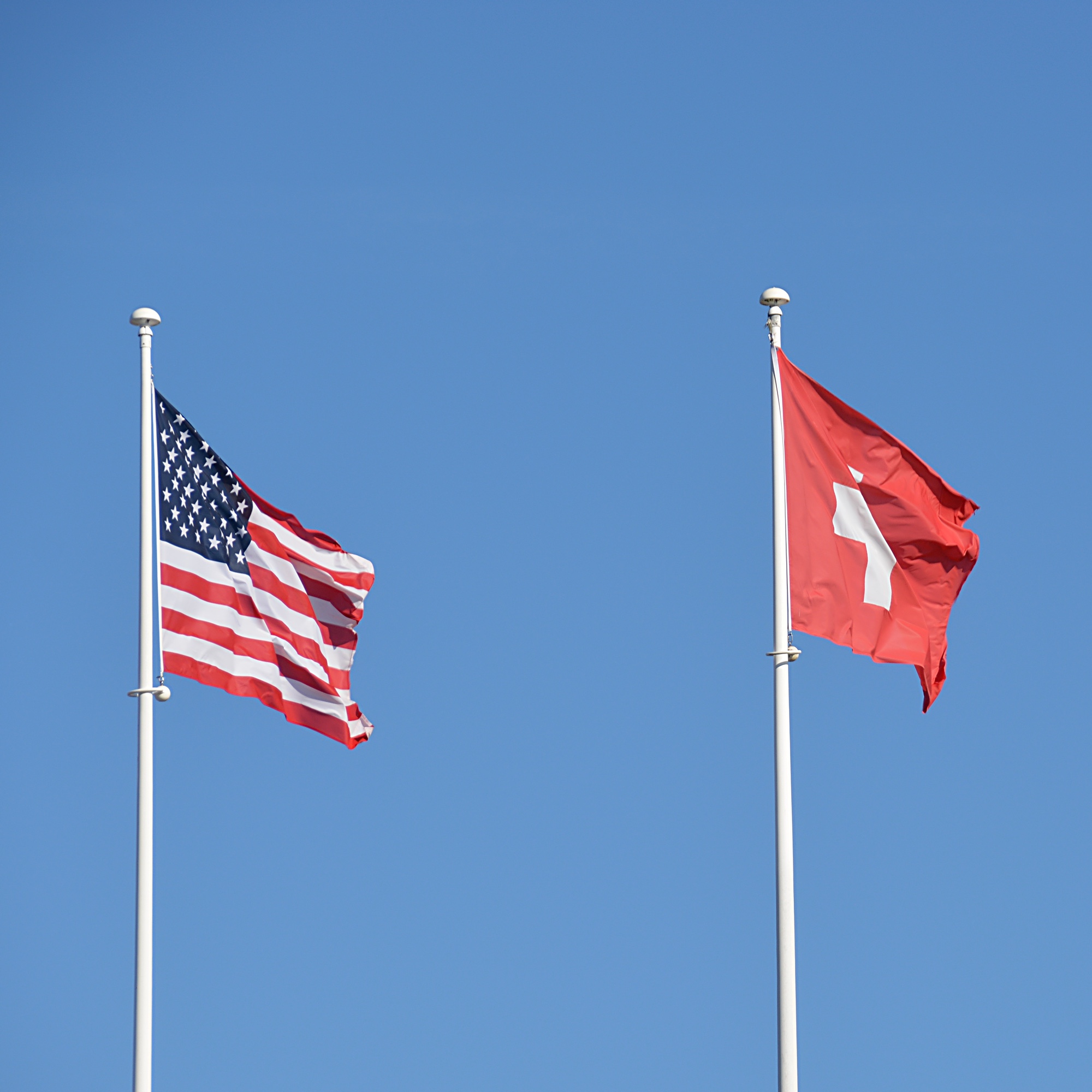 Foto: Wehende Flaggen der USA und der Schweiz