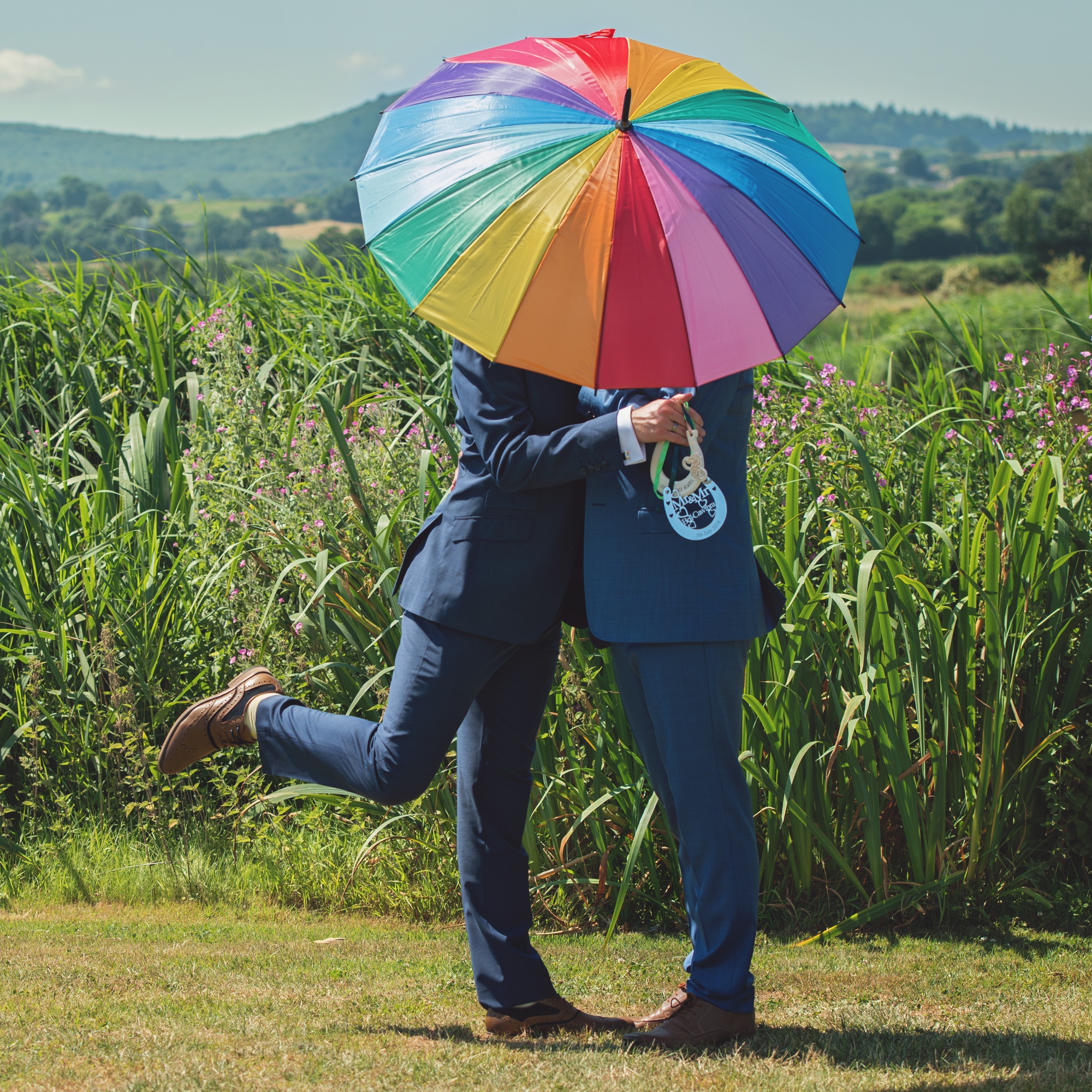 Foto: Gleichgeschlechtliches Paar hinter Regenbogen-Schirm